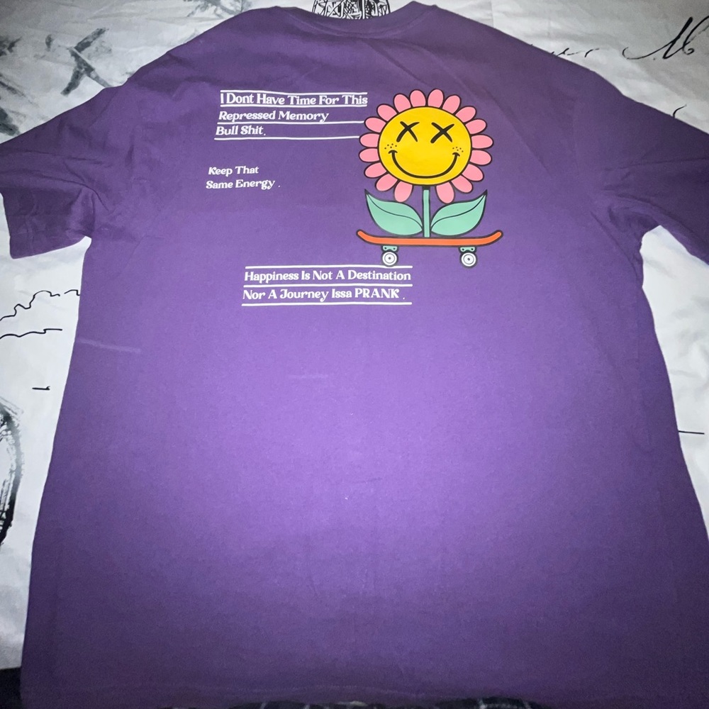 Here I am selling a purple graphic shirt .